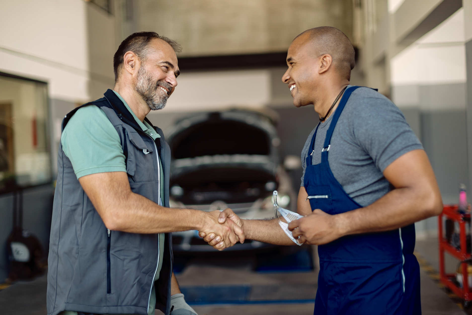 A car mechanic and customer shaking hands